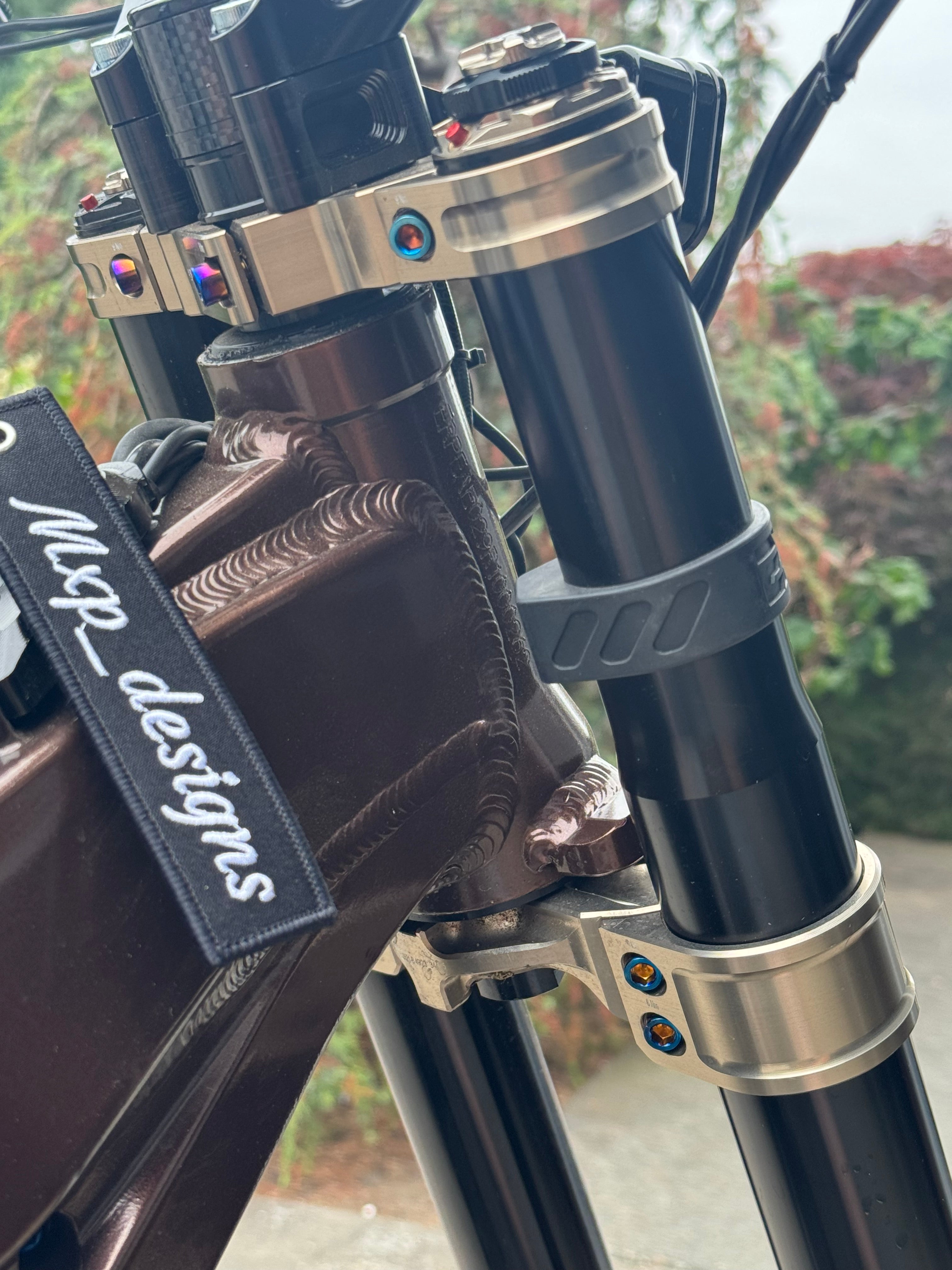 Mxp_designs titanium fork bolts with a sleek metallic finish, designed for secure attachment and durability in bicycle components.