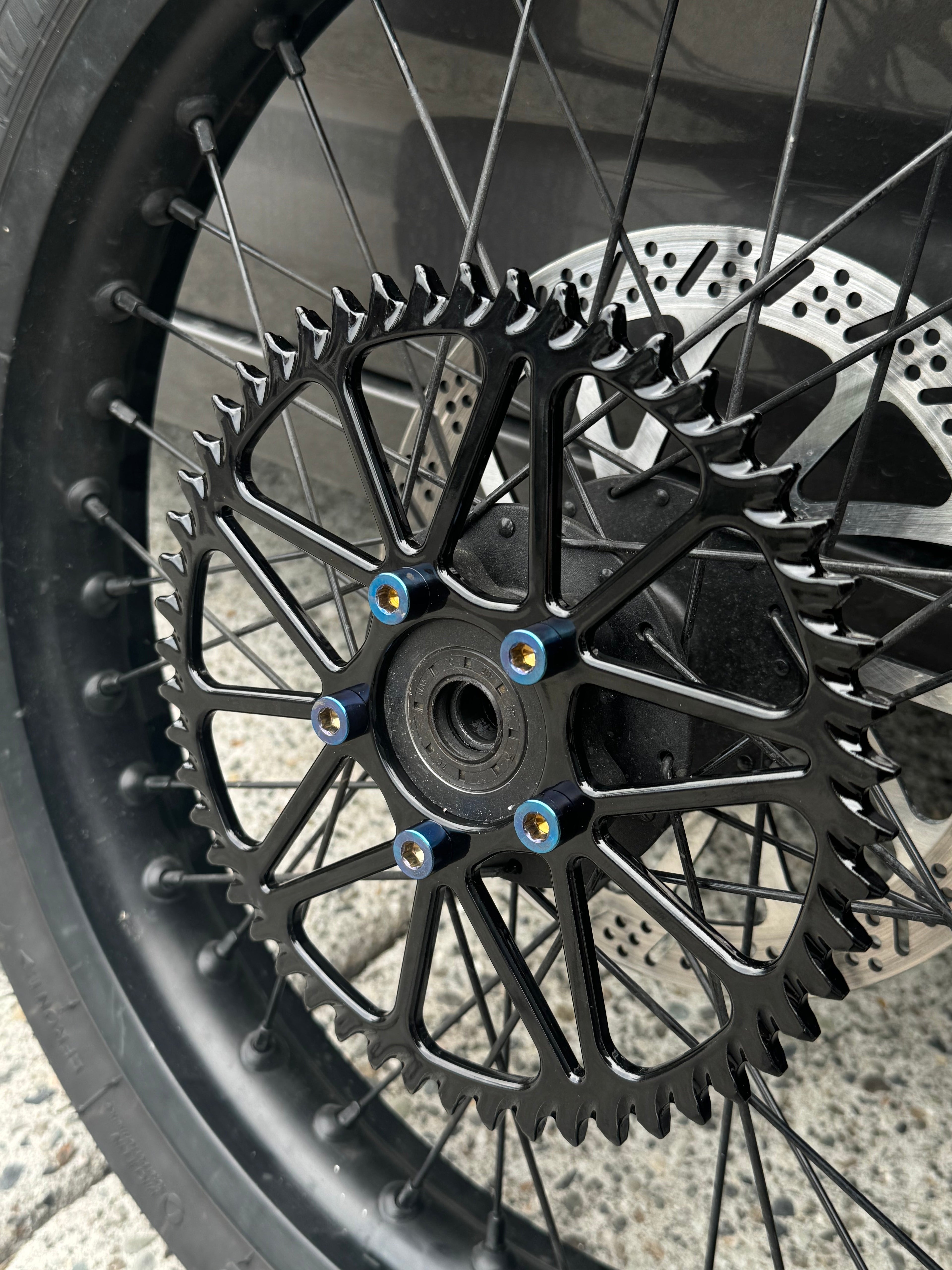 Titanium sprocket bolt set by Mxp_designs, showing close-up of shiny titanium bolts on a black background for durability and precision.