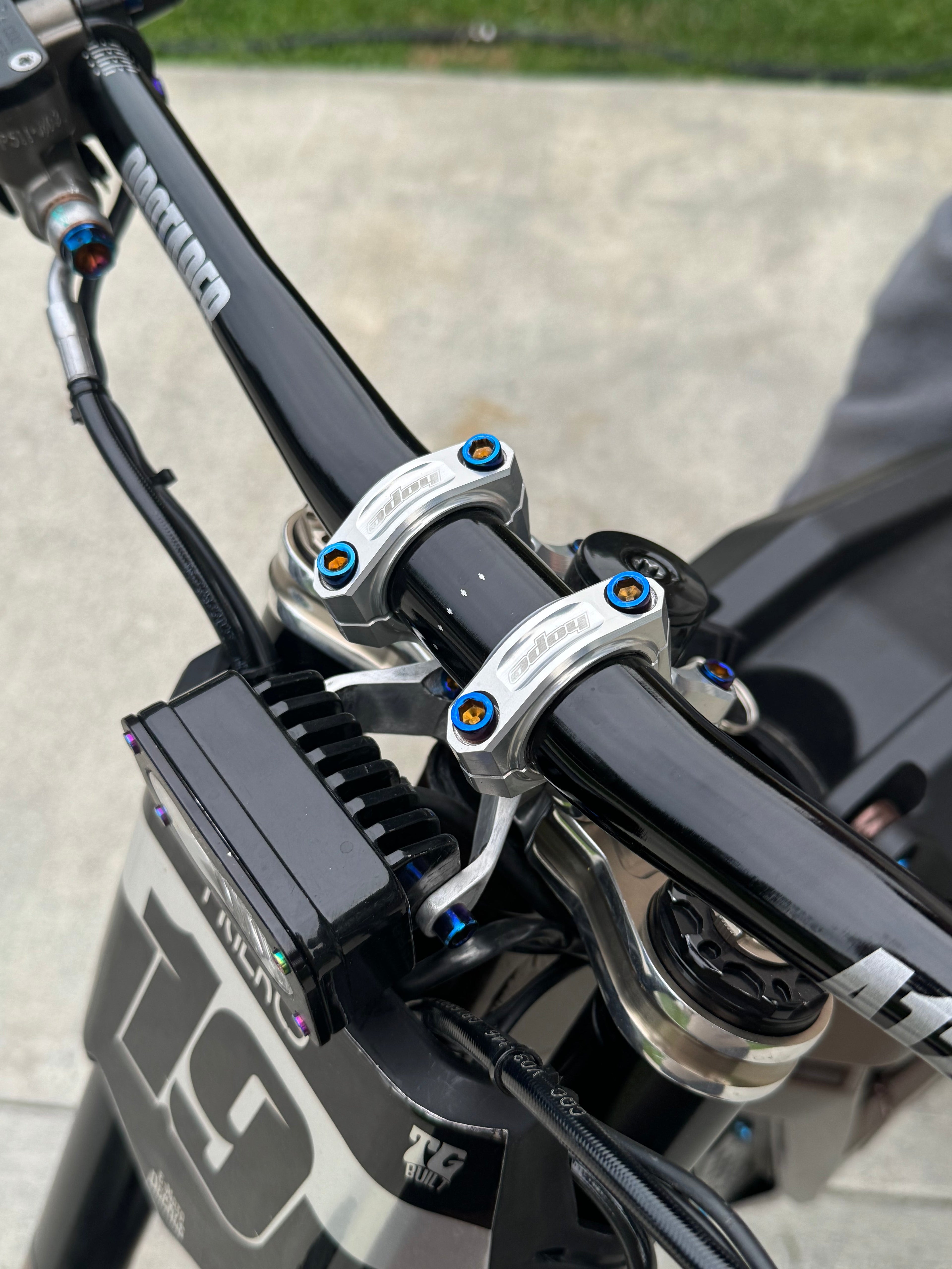 Close-up of MXP_designs direct stem titanium bolts showing sleek metallic finish and precise threading.