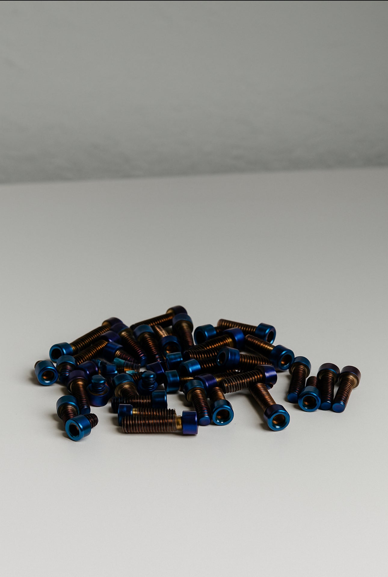 Mxp_designs titanium sprocket bolt set with multiple silver bolts, close-up of the high-quality metal fasteners on a white background.