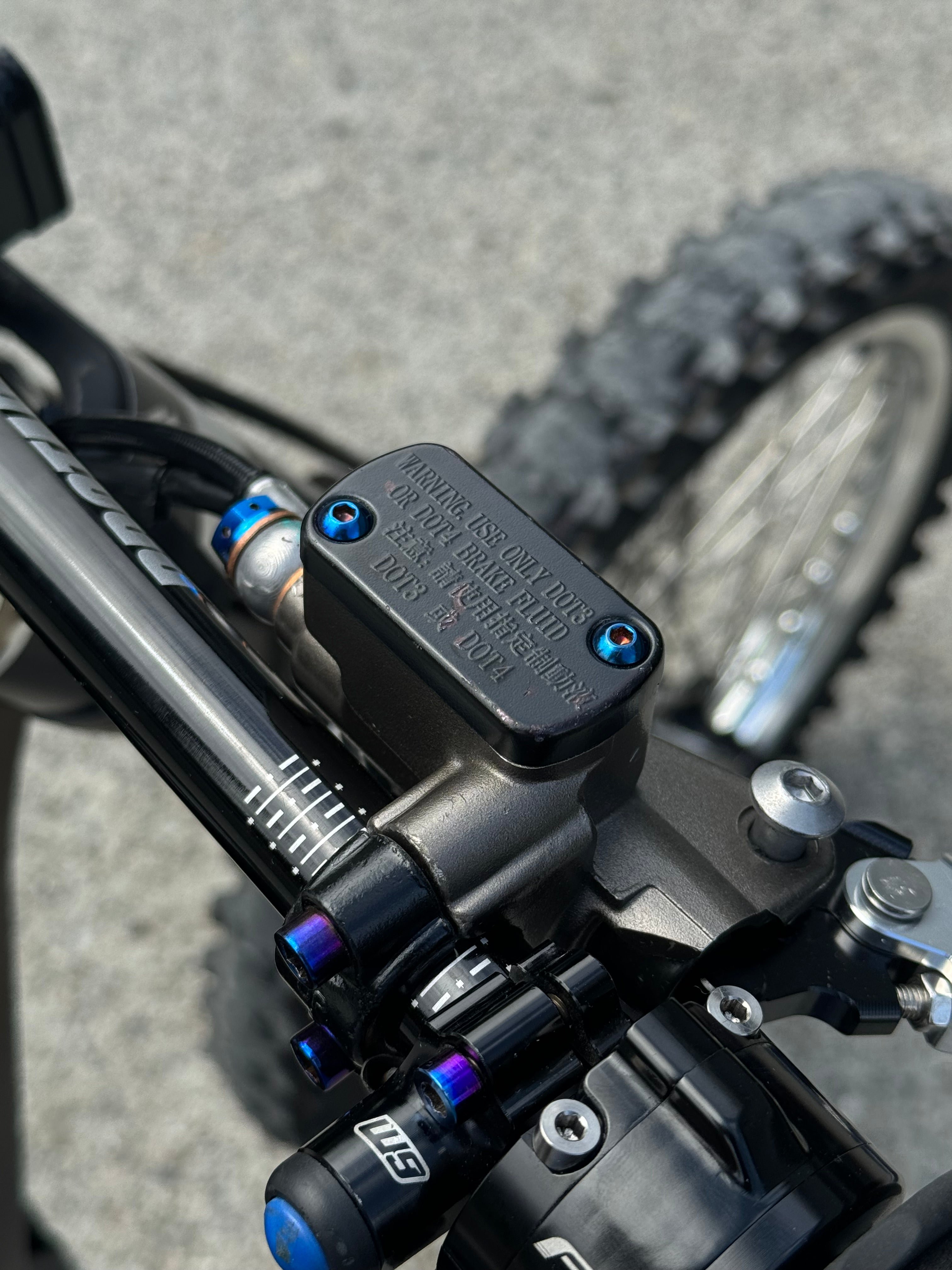 Titanium brake reservoir cap bolts by Mxp_designs, showcasing shiny, durable fasteners for motorcycle or vehicle brake systems.