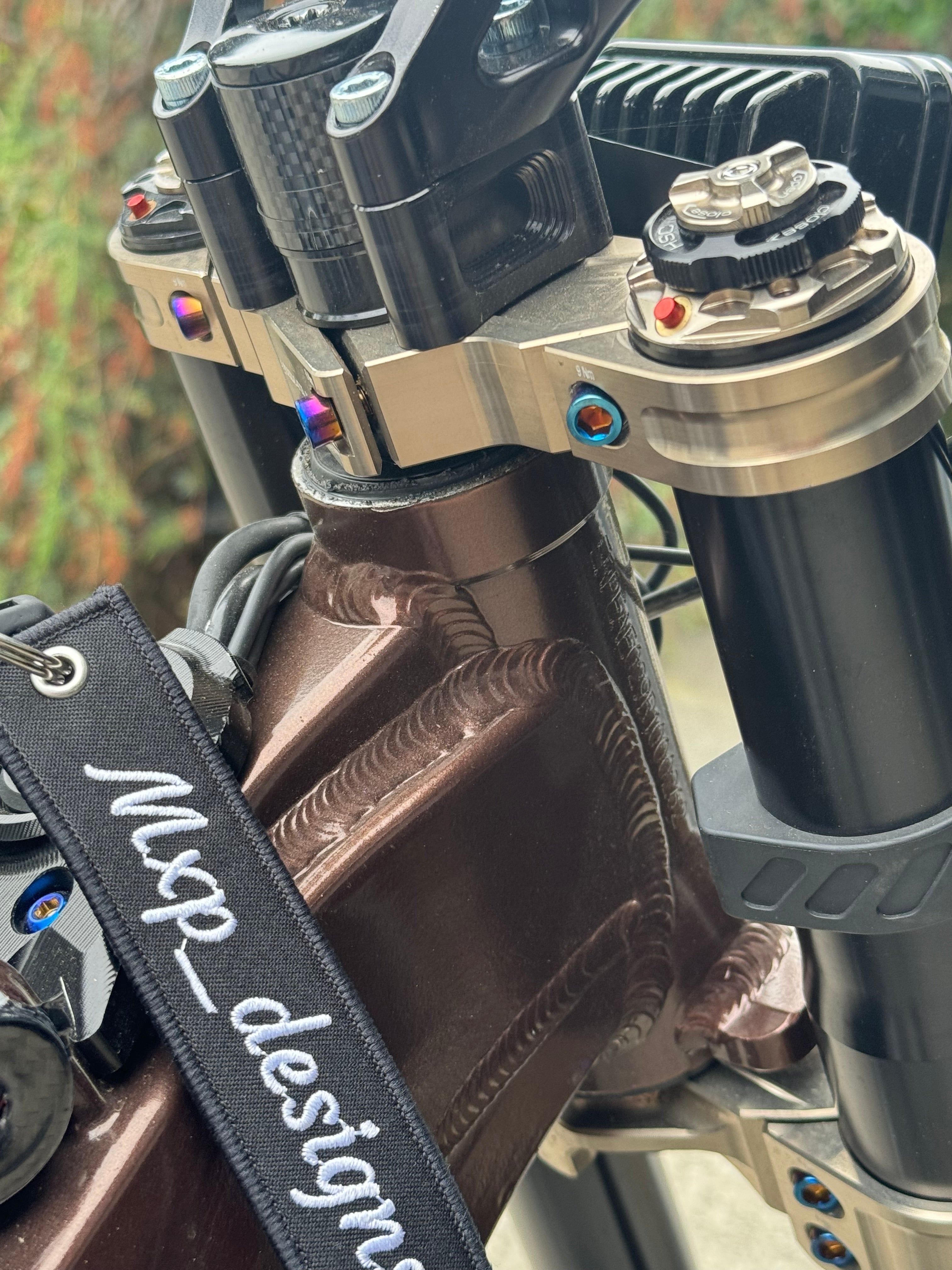 Titanium fork bolts by Mxp_designs, showing shiny, precision-machined metal bolts for bicycle or machinery applications.