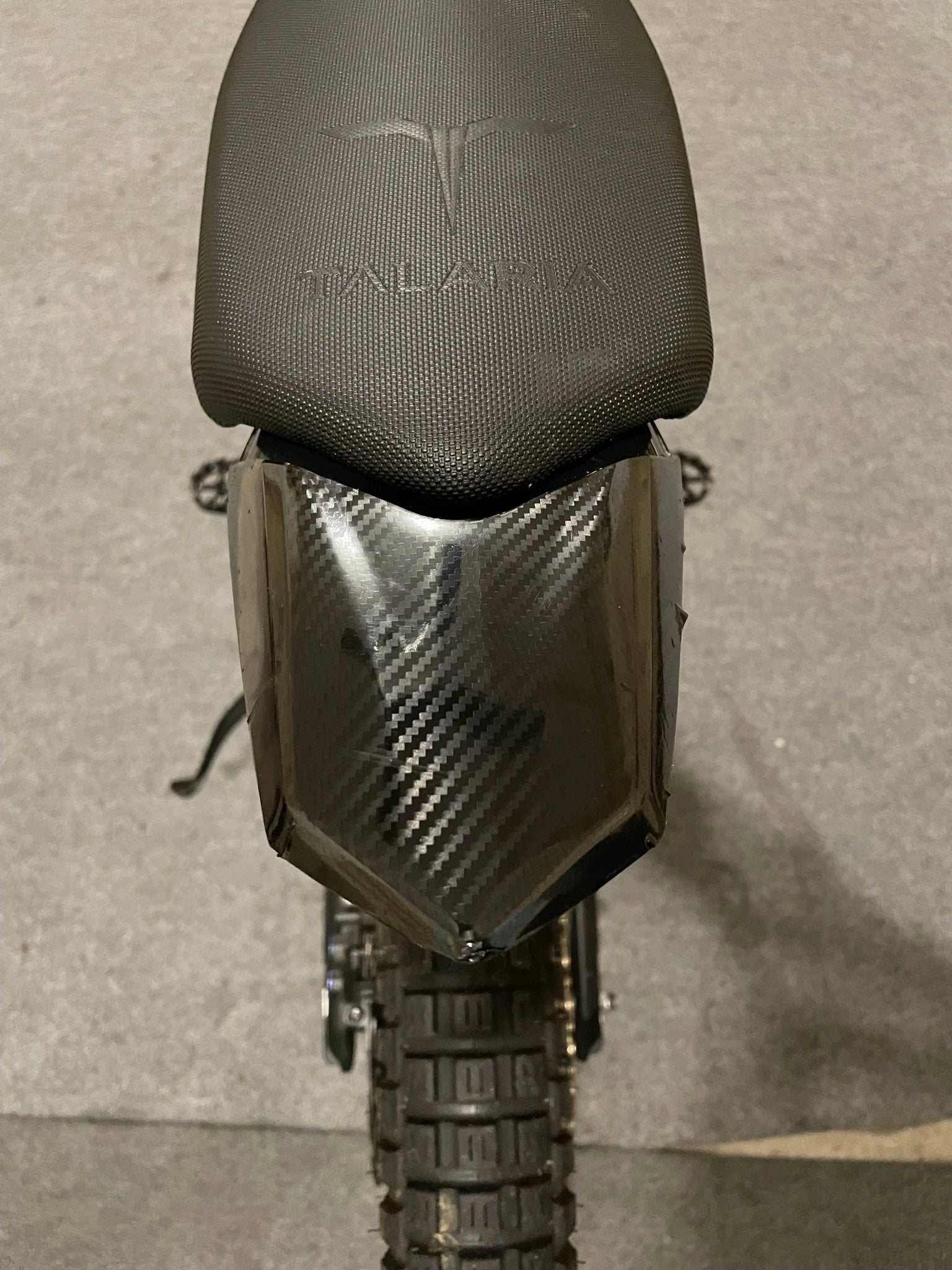 Carbon fiber vinyl wrap kit for Talaria Mx3/Mx4 by MXwraps, featuring sheets of textured black carbon fiber material.