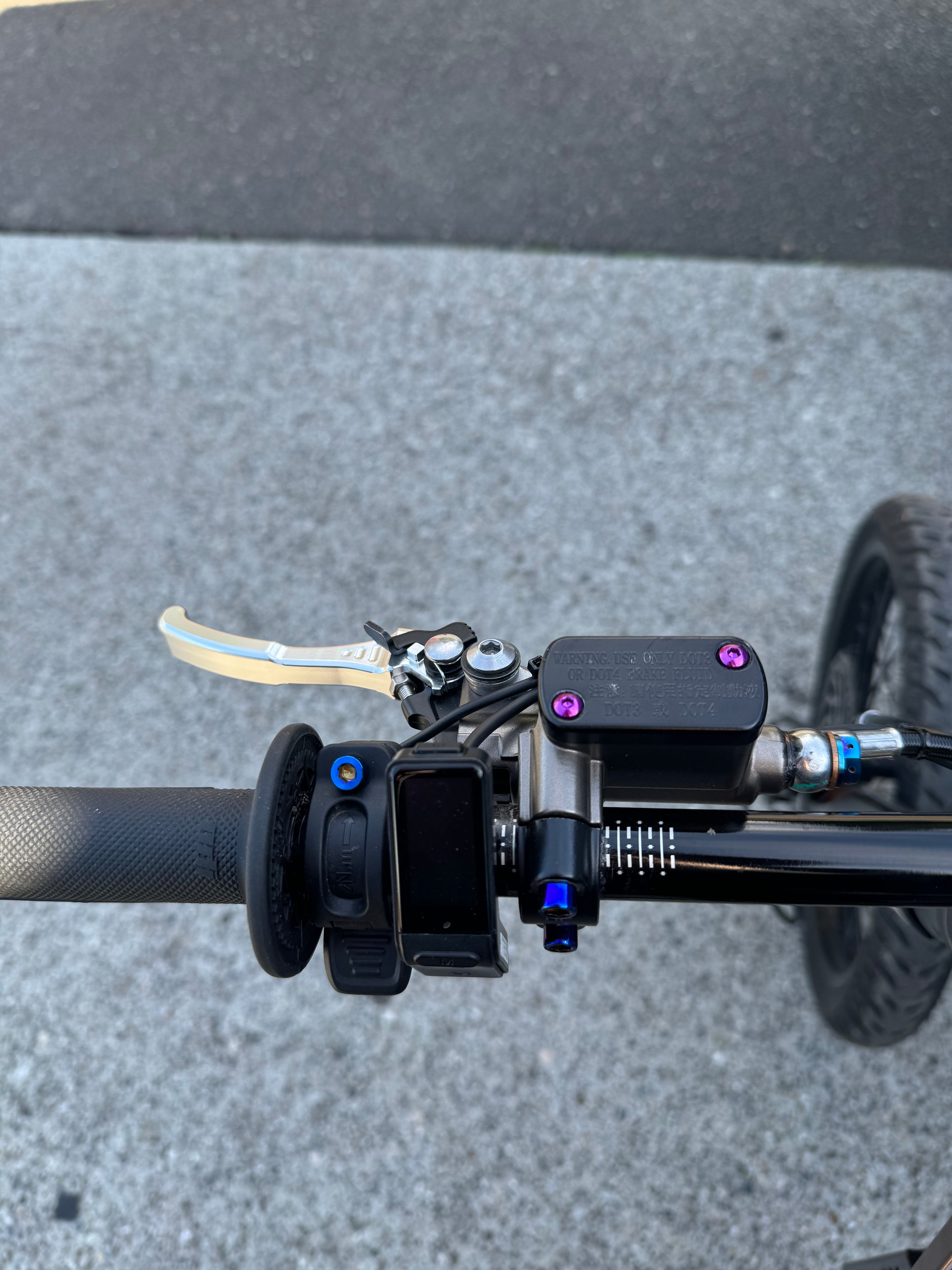 Titanium brake reservoir cap bolts from Mxp_designs, showing close-up of sleek, durable fasteners for motorcycle brake system.