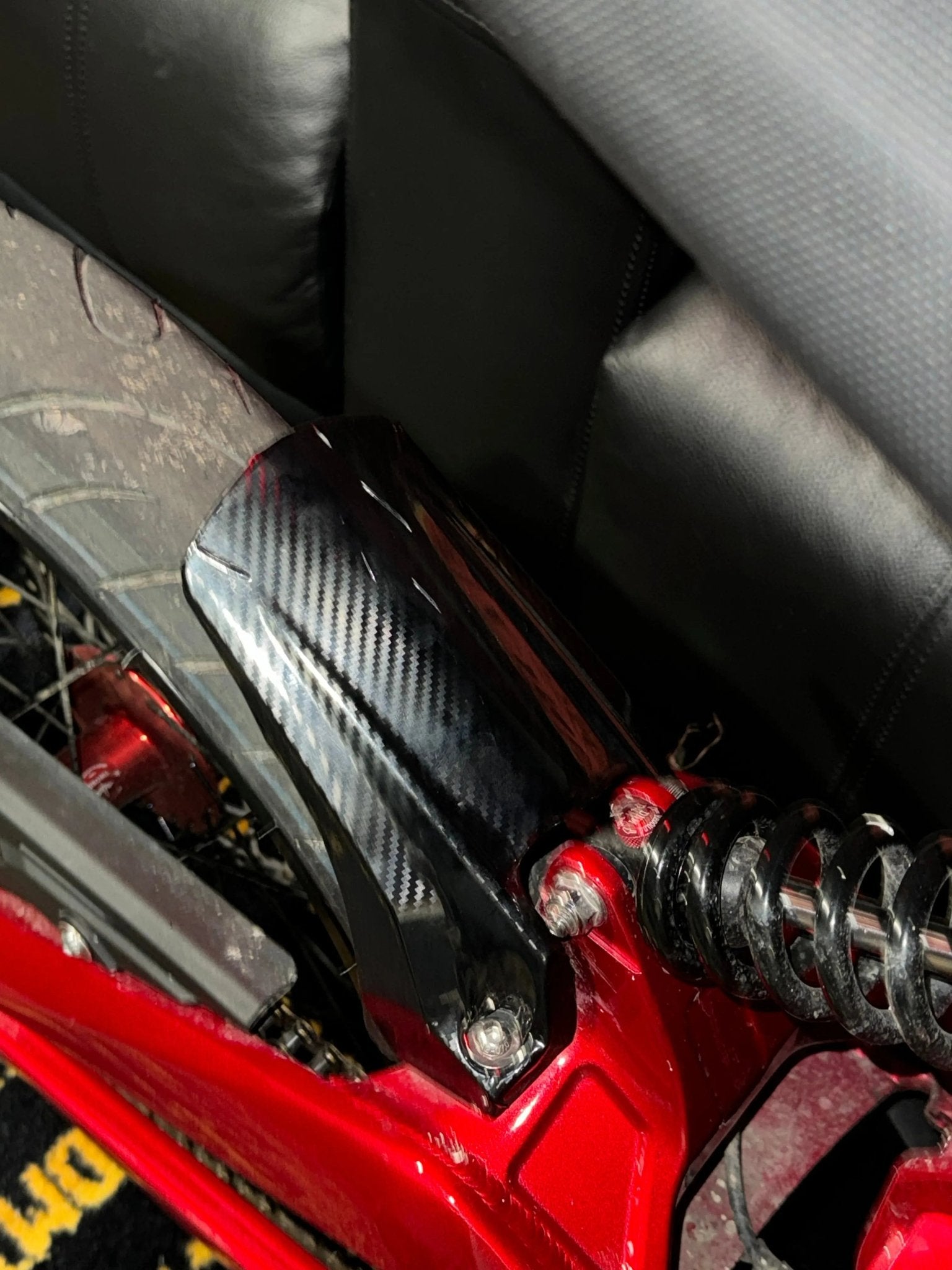 MXwraps Talaria XXX carbon fiber vinyl wrap kit applied to a vehicle surface, showcasing a sleek, textured black finish.