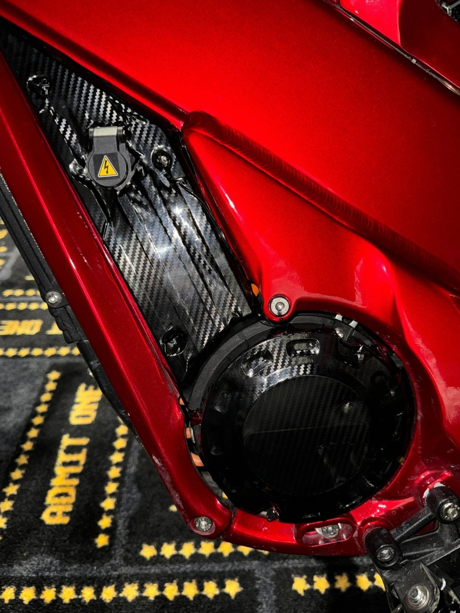 MXwraps Talaria XXX carbon fiber vinyl wrap kit applied to a vehicle for a sleek, textured carbon fiber finish.